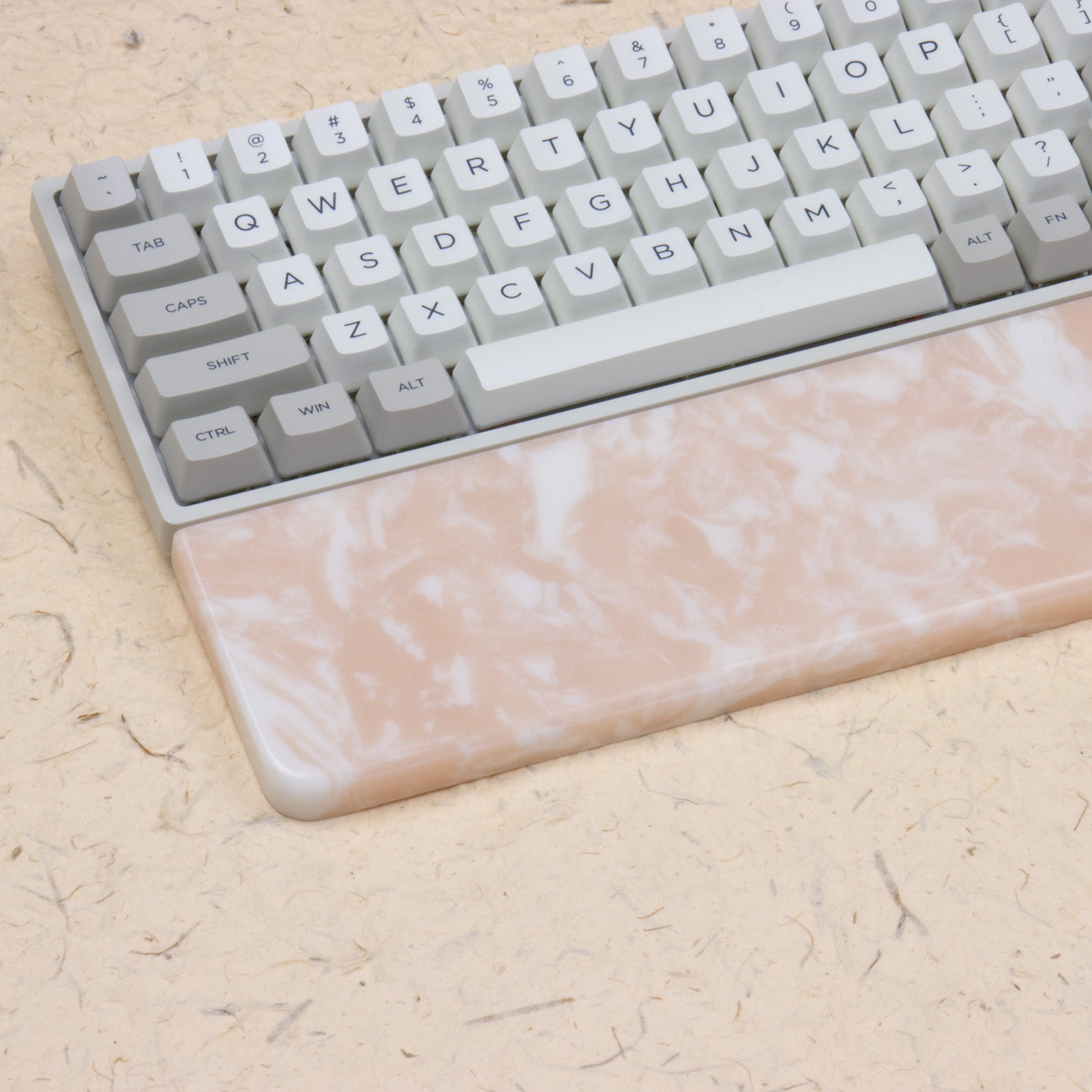 Pink resin wrist rest with keyboards left