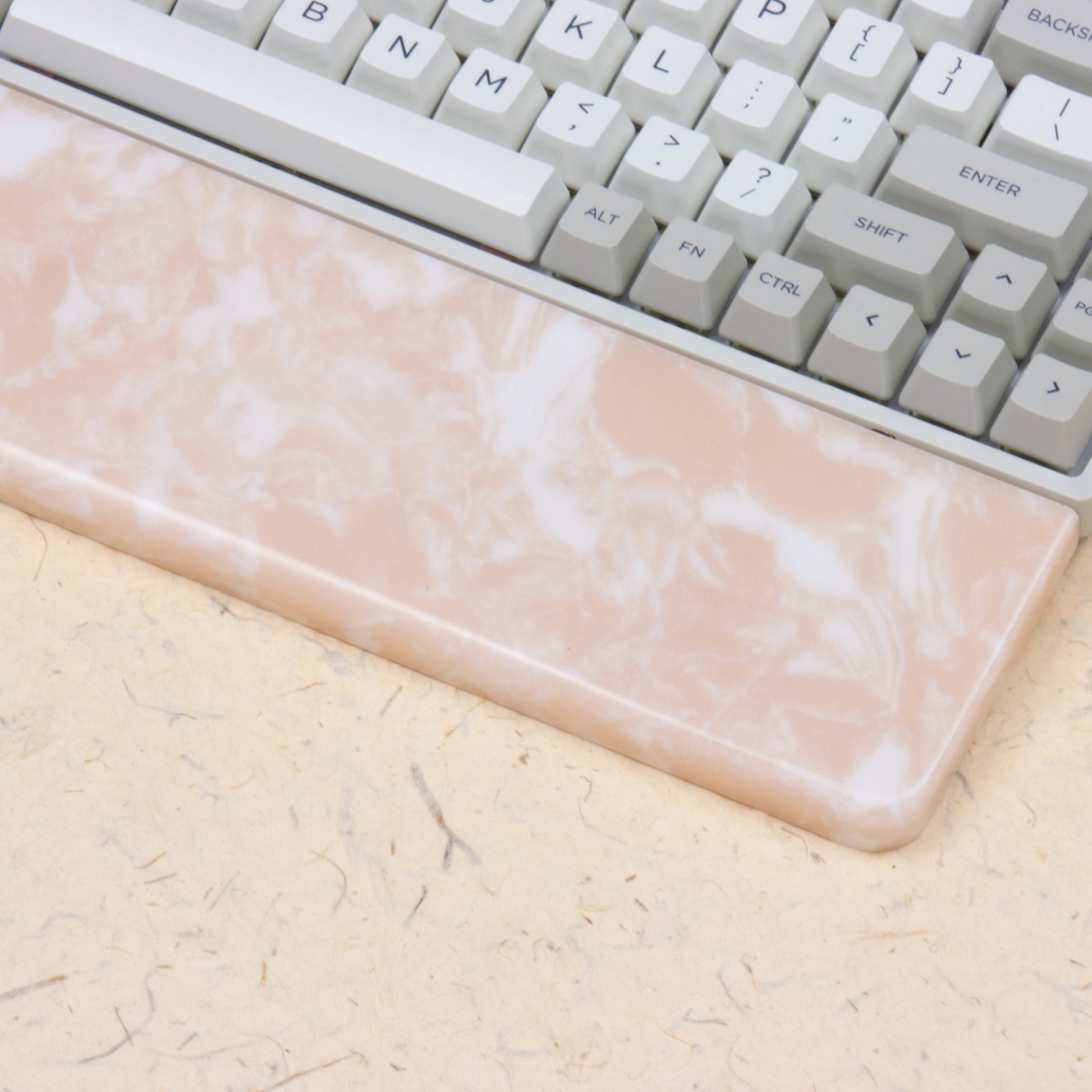 Pink resin wrist rest with keyboards right