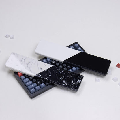 Two dual-tone quartz wrist rests in pure monochrome and textured styles displayed on a mechanical keyboard desk setup