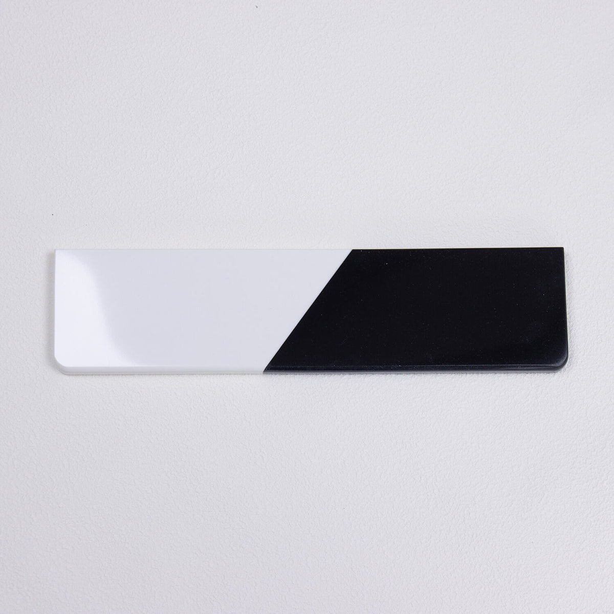 yeswristrest Pure Dual-Tone quartz stone wrist rest with solid black and white diagonal split isolated view