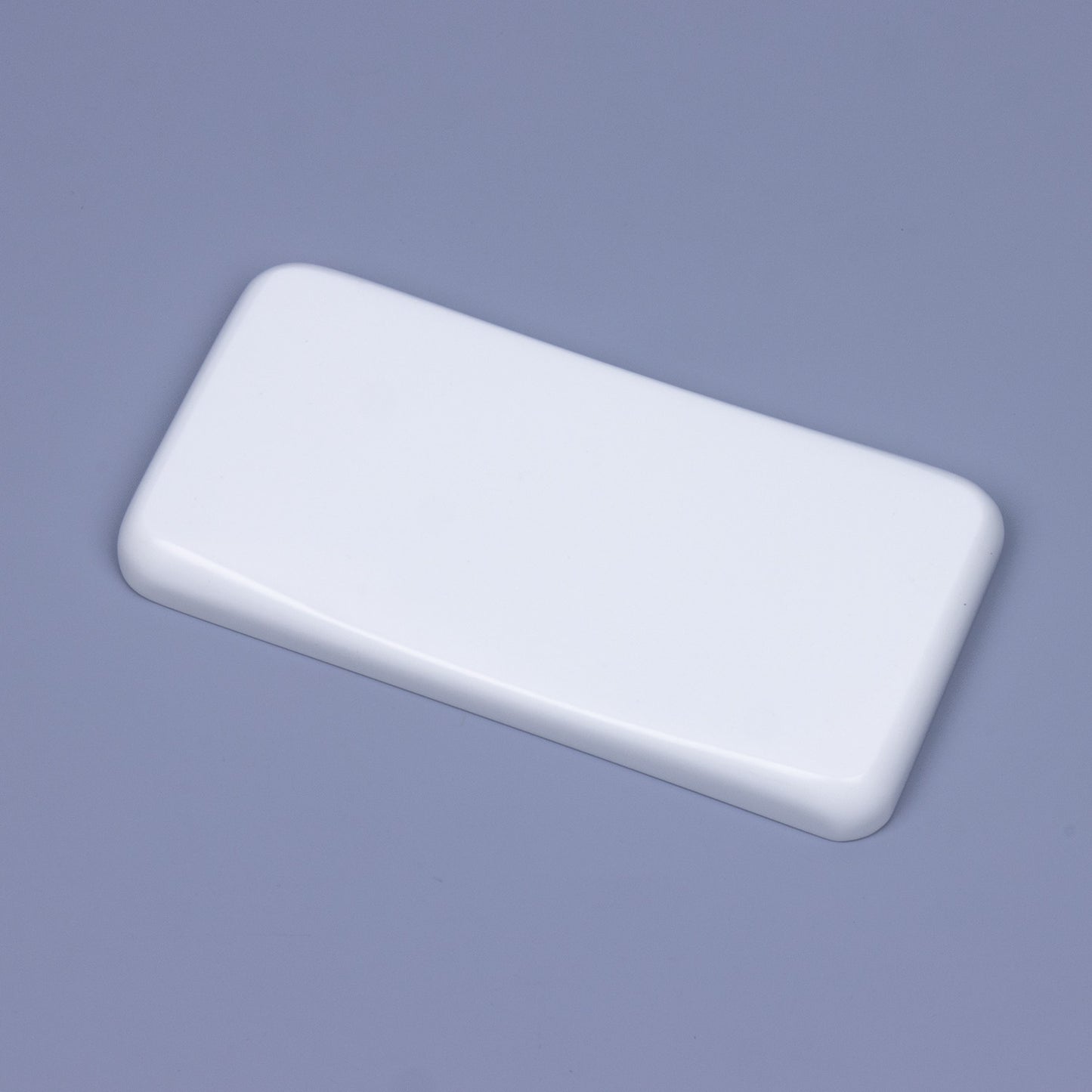 Angled close-up of a minimalist solid pure white quartz mouse wrist rest showing sleek polished chamfered edges and ergonomic sloped contour